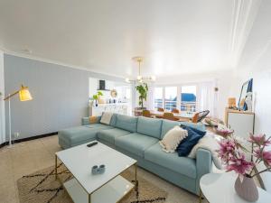 uma sala de estar com um sofá azul e uma mesa em Rapallo III 3 bedrooms on floor 2 em Middelkerke