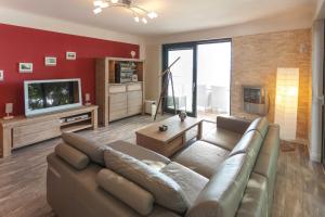uma sala de estar com um sofá e uma televisão em Villa Friede_Marie_ App_ _OstseeWe em Sassnitz