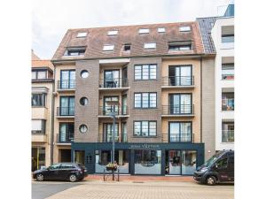 a large brick building with cars parked in front of it at Duplex apartment near the center in Middelkerke
