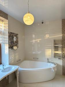 a white bathroom with a tub and a sink at Villa Sofia in Odesa +62 photos