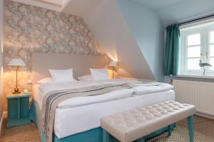Un dormitorio con una gran cama blanca y una ventana en Hotel Watthof en Rantum