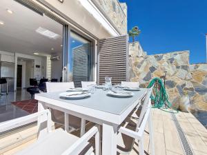 ein weißer Esstisch und Stühle auf einer Terrasse in der Unterkunft Los Alcazares Villa - 9509 in Los Alcázares