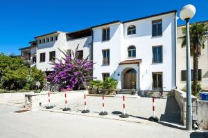 a white building with red poles in front of it at Residence Antonio - Deluxe Apartments & Rooms in Rovinj