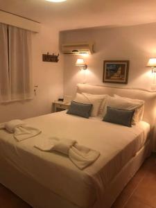 a bedroom with a white bed with two towels on it at Villa Ftenagia in Halki
