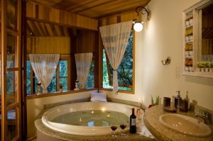 uma casa de banho com uma banheira grande e 2 lavatórios em Pousada Moriá em Visconde de Mauá