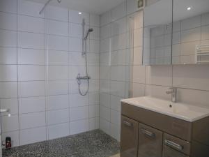 a white tiled bathroom with a sink and a shower at Appartement rénové en plein centre de Palais avec cour ensoleillée, proche du port, animaux acceptés - FR-1-418-222 in Le Palais +8 photos