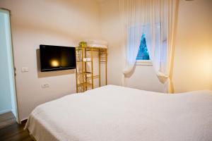 a bedroom with a white bed and a window at lotus beach house in H̱adera