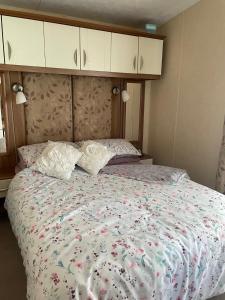 a bedroom with a large bed with flowers on it at Tags caravan park in Skegness