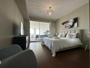 a bedroom with a large bed and a large window at Madeira Palace Residences in Funchal