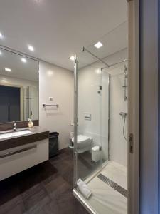 a bathroom with a shower and a sink and a toilet at Madeira Palace Residences in Funchal
