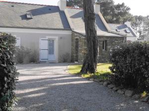 ein weißes Haus mit einem Baum und einer Auffahrt in der Unterkunft Maison Locmaria, 2 pièces, 2 personnes - FR-1-418-223 in Locmaria
