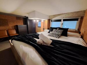a bedroom with a large bed with a towel on it at VibesCoruña - Loft Industrial Comercio in A Coruña