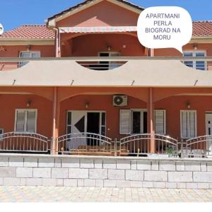 a red house with a sign that reads akhtar patel biological mg mg hospital at Apartments Perla in Biograd na Moru