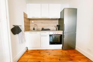 uma cozinha com armários brancos e um frigorífico de aço inoxidável em The Urban Casimir #FG em Grenoble