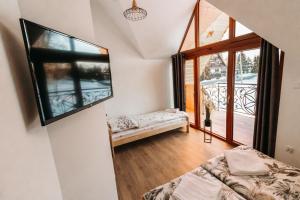 a room with a bed and a large window at Stylove Domki Bańska Niżna Domki z Jacuzzi in Bańska Niżna