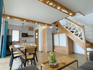 a living room and kitchen with a table and a staircase at Stylove Domki Bańska Niżna Domki z Jacuzzi in Bańska Niżna