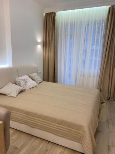 a bedroom with a large bed with a large window at Апартаменти Корфу біля моря in Odesa