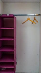 um armário com prateleiras cor-de-rosa num quarto em Erin's bed and breakfast em Dramalj