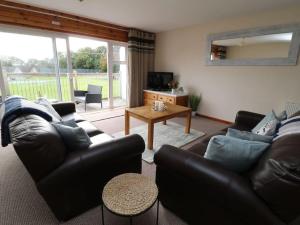 a living room with a couch and a table at Cheerful spacious 2 bedroom holiday home St Anns 12 in Gunnislake