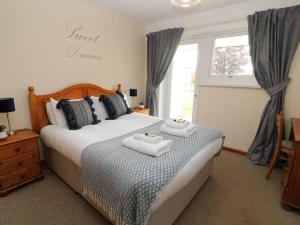 a bedroom with a bed with two towels on it at Cheerful spacious 2 bedroom holiday home St Anns 12 in Gunnislake