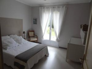 biała sypialnia z łóżkiem i oknem w obiekcie La bastide de LORGUES 83 w mieście Lorgues