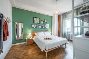 una camera da letto con un letto e una parete verde di DALLA BRUNA - Above the roofs of the centre a Modena