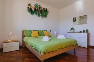 - une chambre avec un lit vert recouvert d'un étendoir dans l'établissement Next Door elegante villa a Bari, à Valenzano