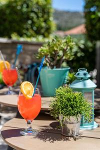 a table with two glasses of orange juice and an orange slice at Stay U-nique Studio apartment in Orašac in Orasac