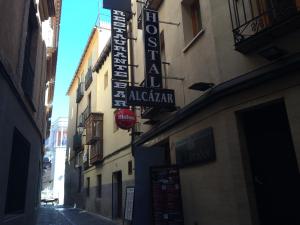 an alley with signs on the side of a building at Hostal Alcázar in Toledo