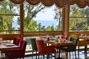 een restaurant met tafels en stoelen en een groot raam bij Emirhan Palace Hotel in Istanbul