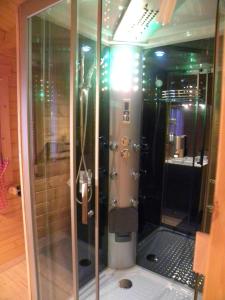 La salle de bains est pourvue d'une douche avec une porte en verre. dans l'établissement IN'D'NOI, à Ajaccio