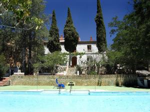 una casa con pista de tenis frente a un edificio en Cortijo Palacete La Tala en Guadix