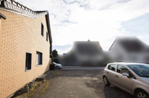 ein Auto, das auf einem Parkplatz neben einem Gebäude parkt in der Unterkunft Häusliches Loft Wohnung Apartment im Herzen von Ratingen in Ratingen