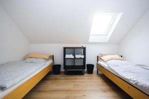 2 Betten in einem Zimmer mit weißen Wänden und einem Fenster in der Unterkunft Häusliches Loft Wohnung Apartment im Herzen von Ratingen in Ratingen