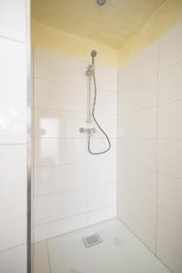 a bathroom with a shower with white tiles at Häusliches Loft Wohnung Apartment im Herzen von Ratingen in Ratingen