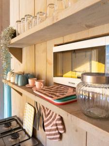a kitchen counter with a microwave and a stove at Glamping tent with bathroom - Tuscany next to sea! in Viareggio
