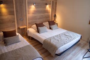 two beds in a room with wooden floors at Au Gai Soleil du Mont-Aiguille in Chichilianne