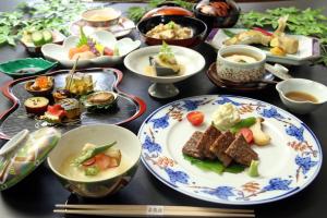 a table with plates of food and bowls of food at GLOCE 養老 千歳楼別邸古民家 l 約250年の歴史を持つ旅館にある古民家を貸し切り in Yoro