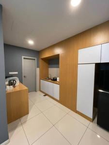 a large kitchen with a counter and a refrigerator at 3bedroom Sutera Avenue Kota Kinabalu by Twen8ty Homestay in Kota Kinabalu