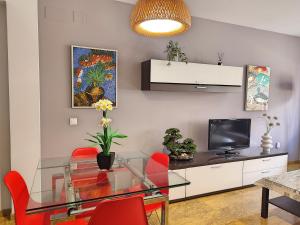 - un salon avec une table en verre et des chaises rouges dans l'établissement Amplio y Moderno Apartamento Lorenzo Ferreira, à Cordoue