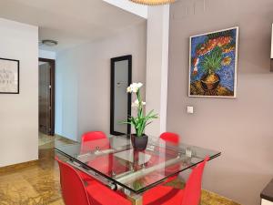 jadalnia ze szklanym stołem i czerwonymi krzesłami w obiekcie Amplio y Moderno Apartamento Lorenzo Ferreira w Kordobie