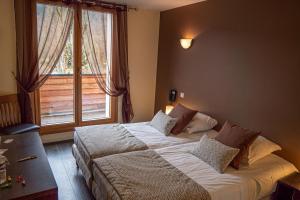 a bedroom with a bed and a large window at Au Gai Soleil du Mont-Aiguille in Chichilianne