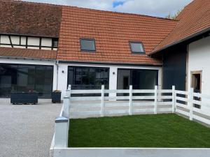 a white fence in front of a house at A la ferme in Kurtzenhouse