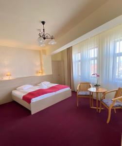 Pensiunea Rix Rooms في فوكشاني: غرفة فندقية بسرير وطاولة وكراسي
