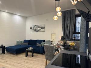 a living room with a blue couch and a table at V Apartment Šibenik in Šibenik