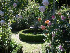 einen Brunnen inmitten eines Gartens mit Rosen in der Unterkunft Villa Schulenburg in Putbus auf Rügen in Putbus