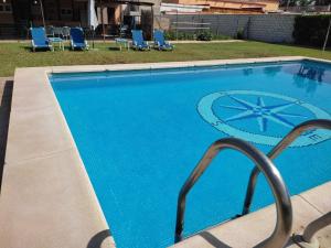 a large blue swimming pool with chairs and chairs at la Casita in Carmona