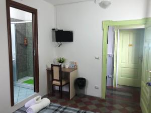 a room with a bed and a desk and a television at B&B L'Alba in Gagliato