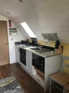 una cucina con lavandino e piano cottura di Bumble Bee Cottage a Plymouth