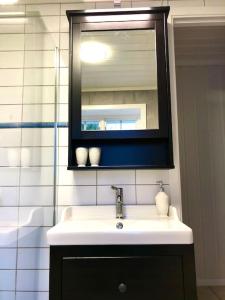 a bathroom with a sink and a mirror and a tub at Idyllic small farm appartment in Tønsberg